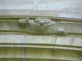 Visage sculpté dans la pierre du porche de l’église de Conques